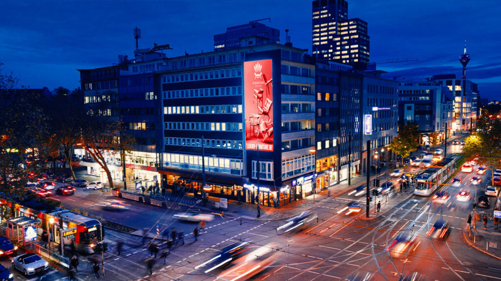 Ansicht von Straße in der Nacht mit großen Plakat von Ströer